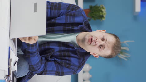 Vertical-video-of-Home-office-worker-man-looking-emotional-at-camera.